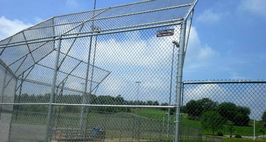 The backstop fencing of this baseball field is made of chain link fence.