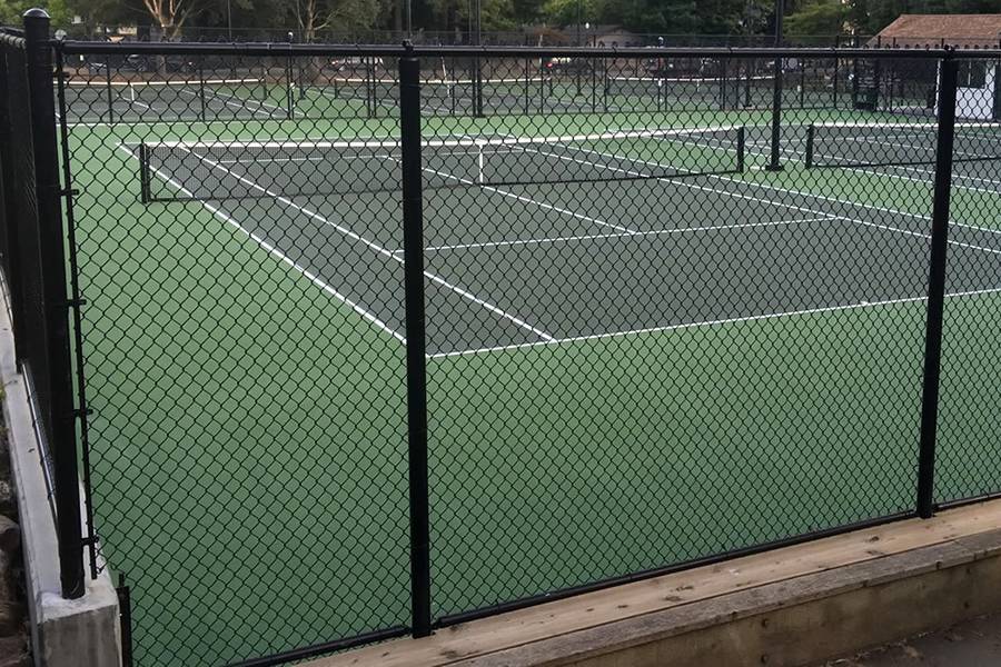 Black chain link fence is used to surround tennis courts.