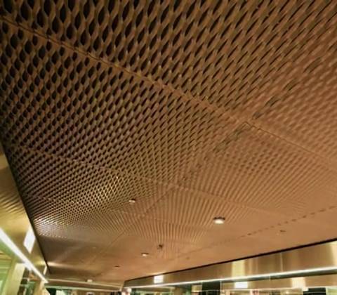 Brass expanded metal ceiling covers the concrete ceiling.