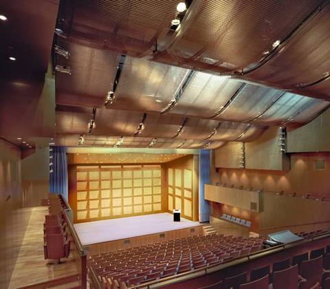 Brass woven mesh ceiling hang overhead in a concert hall.