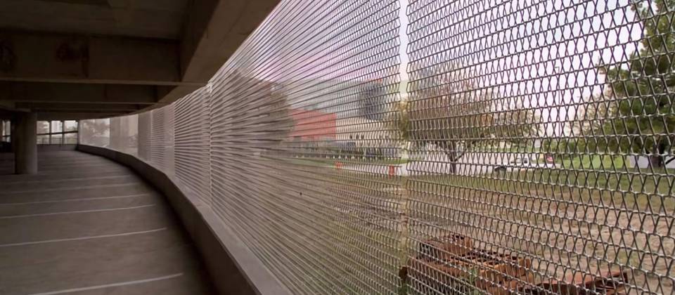 Brass spiral link mesh as building facade in a park.