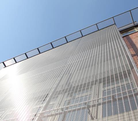 Woven wire mesh installed on the surface of a building.