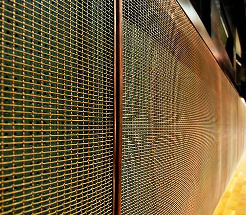 Golden brass crimped wire mesh facade.
