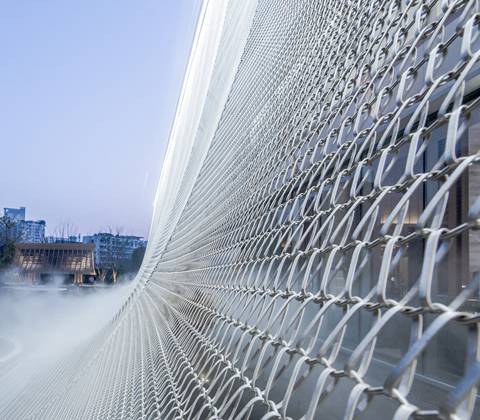 Golden Spiral link mesh building facade and stair is covering on the surface of a building.