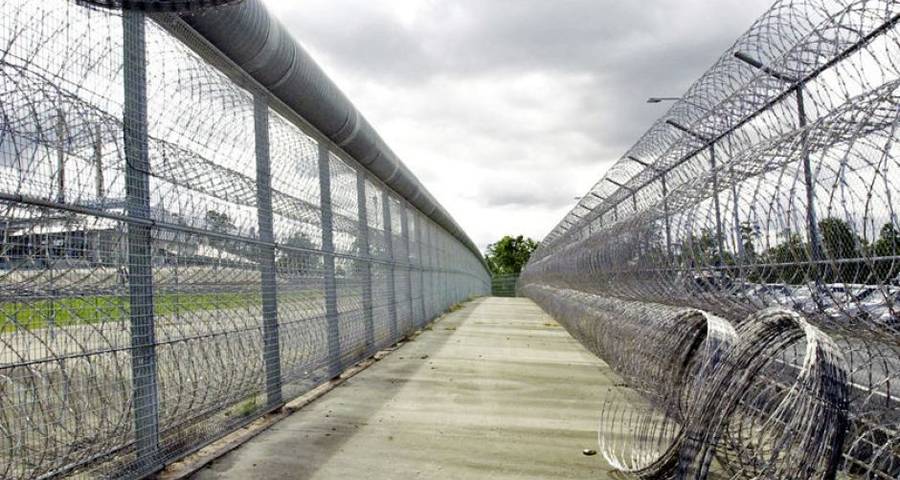 Durable razor wire as prison fence ran along a walkway.