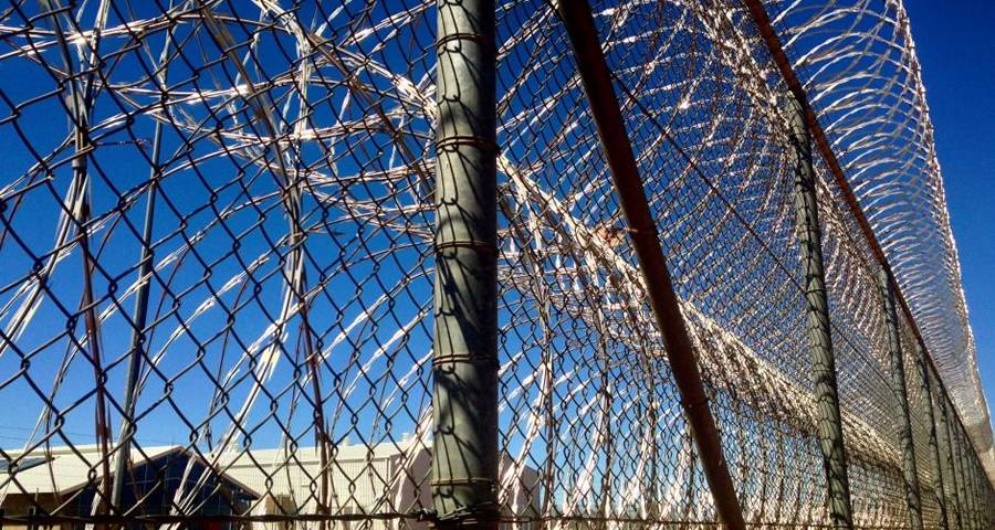 Concertina razor wires stacks against chain link fence very close when act as prison fence.