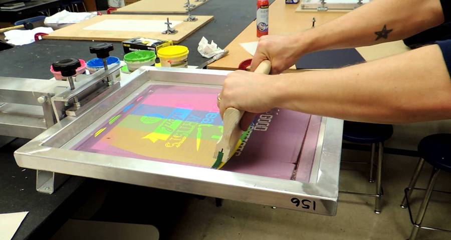 Stainless steel printing mesh applied to screen printer, and a man is printing image now.