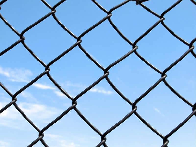 Chain link fence display, its wires interlock with each other forming diamond openings.