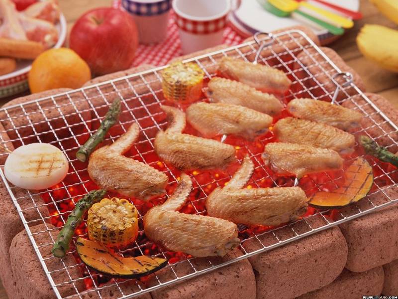 Crimped barbecue grill mesh on stone stove, lavish food have cooked already on it.