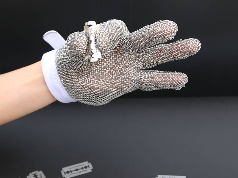Stainless steel mesh gloves wearer hold a sharp blade.