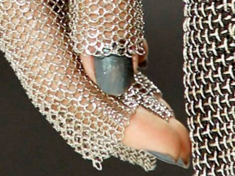 A bright color chainmail gauntlet on a model`s hand.