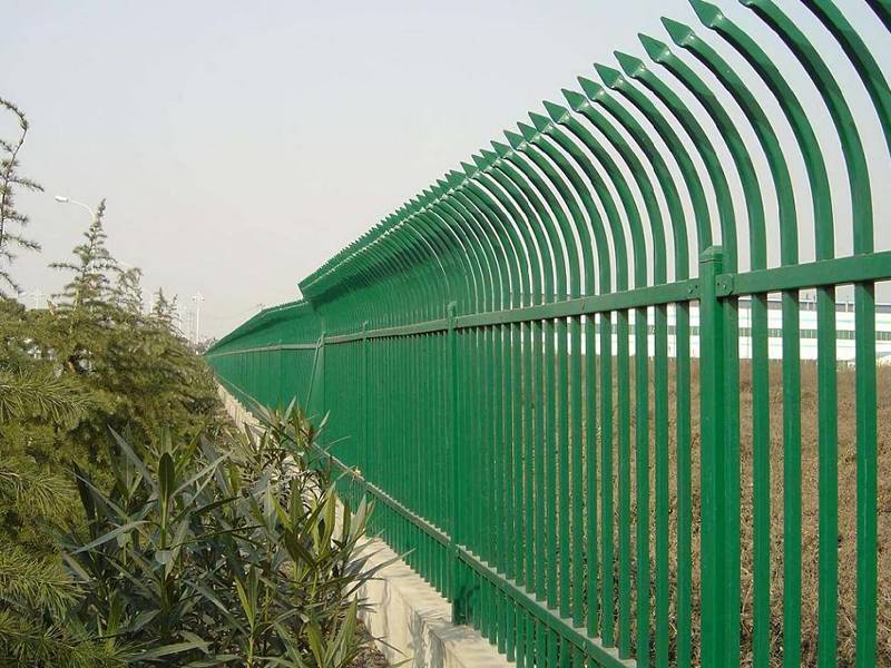 A close-up picture of green hot-dip galvanized steel picket fence with single curved top.