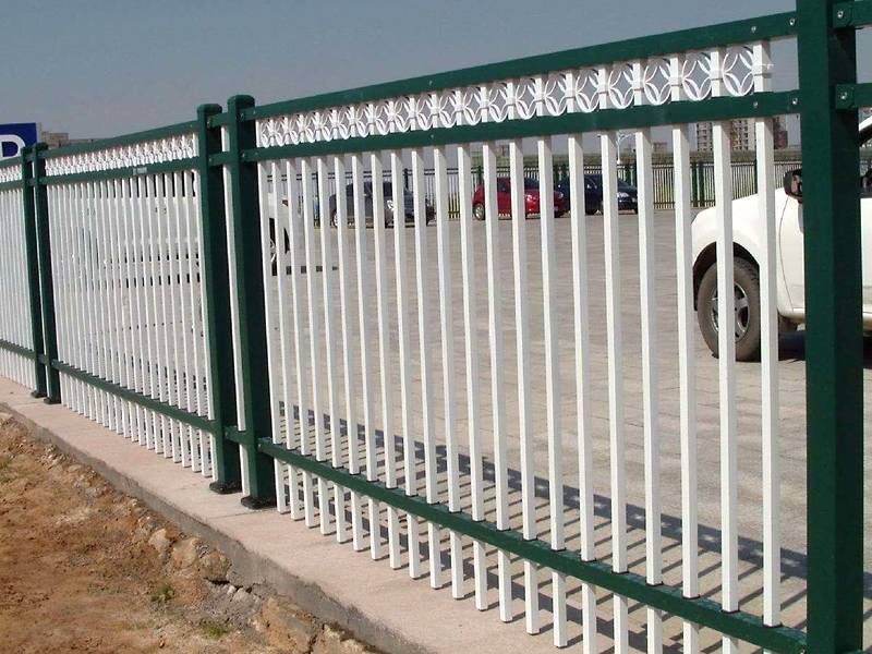 A close-up picture of hot-dip galvanized steel picket fence with flat top and decorative rings which installed as parking lot guardrail.