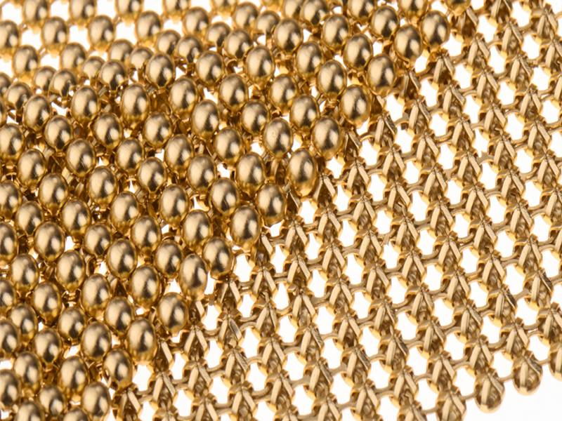 A close-up picture of golden metallic fabric cloth, the mesh structure is eye-catching.