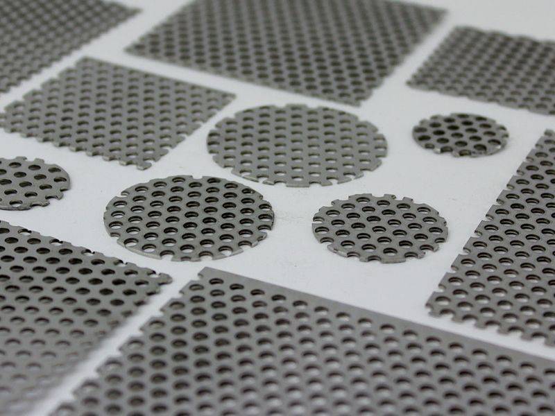 There are several perforated filter discs displayed, some have been cut into round discs.