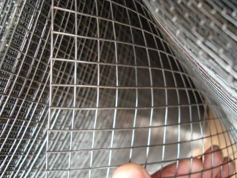A piece of welded wire plaster mesh in a man's hand.