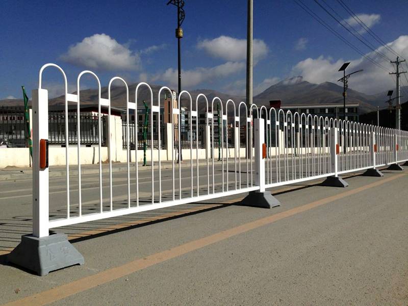 Bow top road fence placing in the middle of sidewalk and driveway.