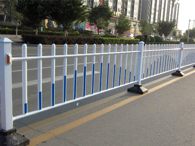White and blue spear top road fence placing in the street.