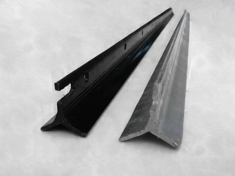 There is a black Y post/star picket and a galvanized Y post/star picket placed together on the ground.